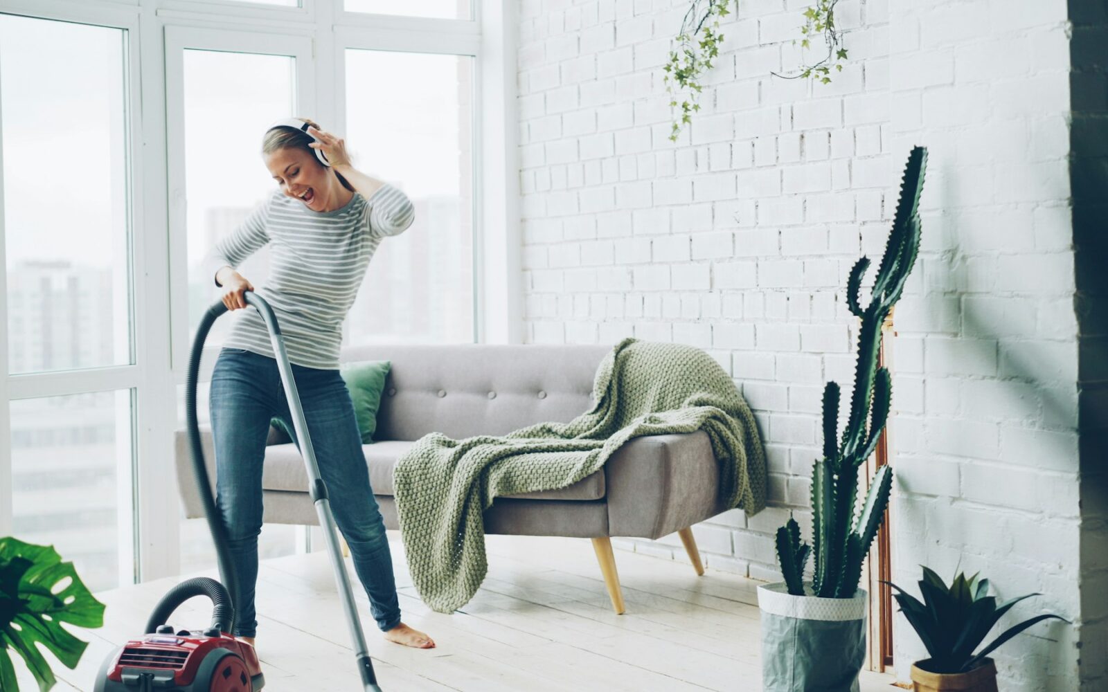 Personne passant l’aspirateur dans un salon lumineux