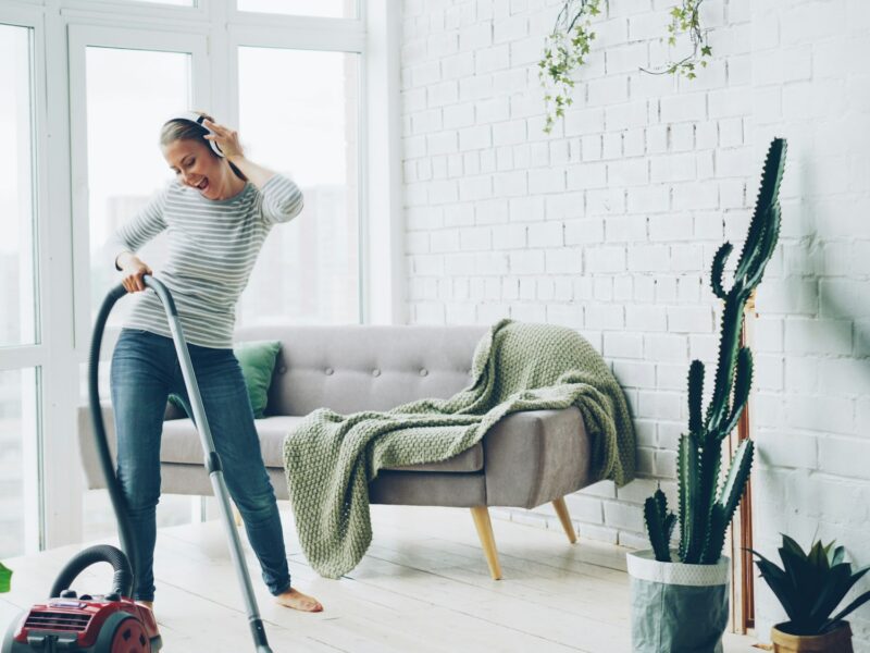 Personne passant l’aspirateur dans un salon lumineux
